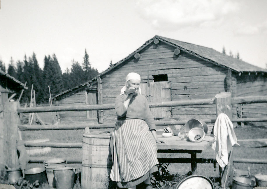 Photo of a woman called Karin Sundell, blowing the horn at a fäbod in Hälsingland sometime in the 1930s.