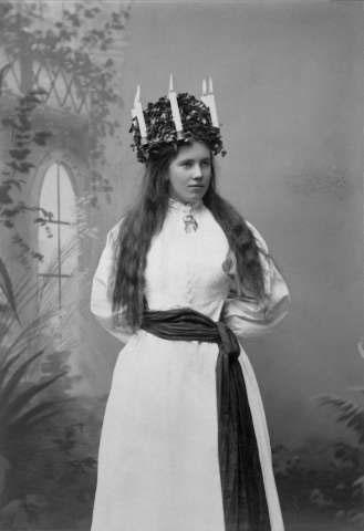 Studioporträtt av luciaklädd kvinna.